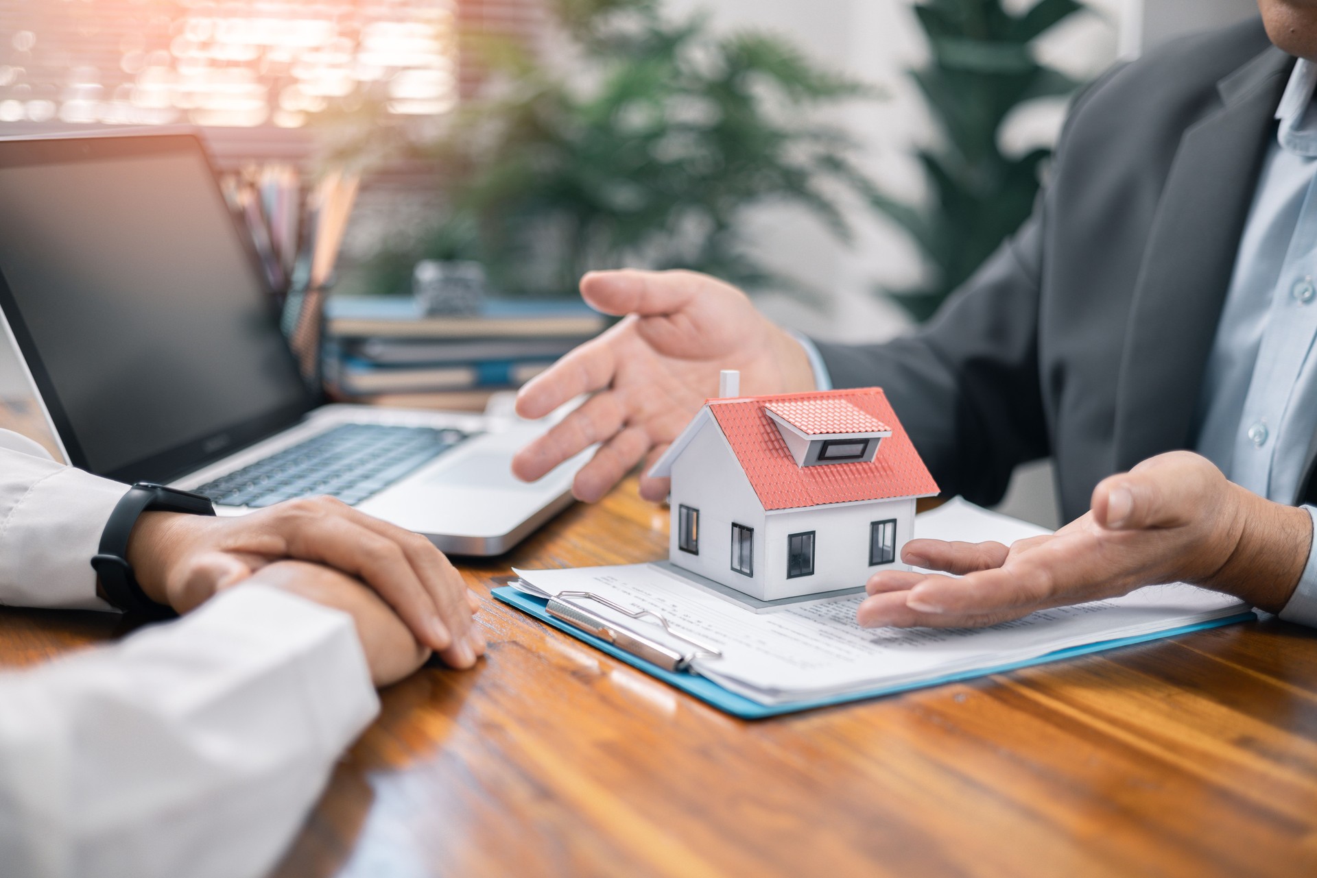 Real estate broker agent presenting and consult to customer to decision making sign insurance form agreement, home model, concerning mortgage loan offer in office. real estate agents about renting